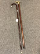 An antique silver mounted walking cane together with a brass mounted 'tipple' stick.