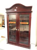 A mahogany double door wall cabinet bearing Matchbox advertising