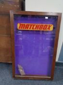 A mahogany glazed door wall cabinet bearing Matchbox advertising