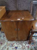 A walnut double door cabinet and two oak chairs