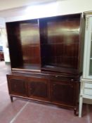 A set of continental open bookshelves fitted with cupboards beneath