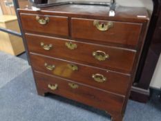 A George III mahogany five drawer chest with brass drop handles on bracket feet