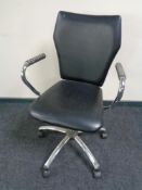 A black PVC swivel adjustable armchair on chrome legs