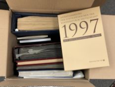 A box containing eight stamp albums, world stamps in the main.