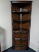 An Ercol corner cupboard fitted with shelves