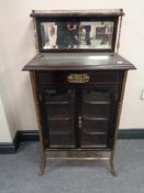 A 19th century mahogany and brass mirrored back music cabinet fitted a drawer and three internal