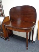 A mahogany demi lune turnover top tea table on reeded legs