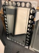 A black circular design glass mirror,