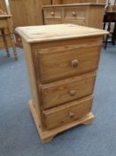 A pine three drawer bedside chest