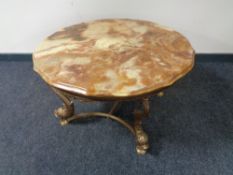 A shaped onyx coffee table on a brass base