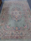 A green fringed floral Chinese woolen rug