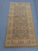 A woolen rug of geometric design on green ground