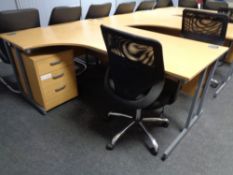 A corner office desk with three drawer pedestal and swivel adjustable armchair