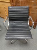 A Vitra Charles Eames designed Alu swivel armchair upholstered in black leather with chrome frame