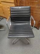 A Vitra Charles Eames designed Alu swivel armchair upholstered in black leather with chrome frame