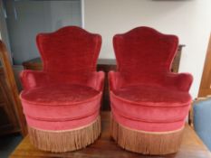 A pair of salon armchairs in red tasselled upholstery