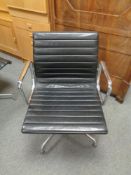 A Vitra Charles Eames designed Alu swivel armchair upholstered in black leather with chrome frame