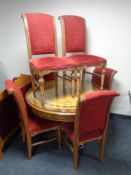 A circular Syrian style ornate glass topped pedestal dining table and six chairs upholstered in red