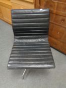 A Vitra Charles Eames designed Alu swivel chair upholstered in black leather with chrome frame