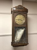 An early twentieth century oak eight day wall clock