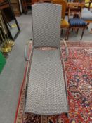 An adjustable garden lounger with teak arm rests