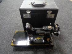 A small Singer hand sewing machine in carry case