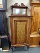 A nineteenth century walnut bow fronted cabinet on cabriole legs with mirror back