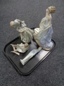 A tray of three Lladro figures, together with one Nao figure.