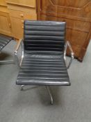 A Vitra Charles Eames designed Alu swivel armchair upholstered in black leather with chrome frame