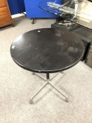 A black ash contemporary circular table on chrome four way pedestal