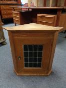 An oak wall cabinet with leaded glass door