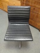 A Vitra Charles Eames designed Alu swivel chair upholstered in black leather with chrome frame