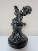 A bronze figure of a cherub on marble plinth