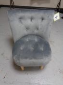 A contemporary buttoned dralon bedroom chair on pine legs