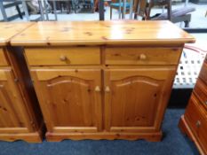 A pine double door cabinet fitted with two drawers