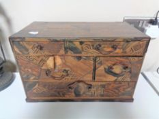 A Japanese mixed wood parquetry six drawer table chest