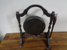 An antique gong and beater on oak stand