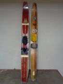 A pair of Freyrie water skis together with a wooden solo ski
