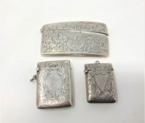 A curved silver card case with engine turned decoration, together with two similar vesta cases.