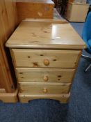 A pine three drawer bedside chest