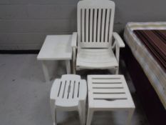 A white plastic steamer armchair together with two white coffee tables and pair of stools