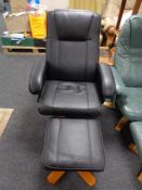 A black leather swivel relaxer chair with stool