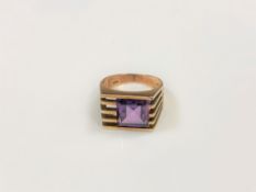A 14ct gold 70's style ring set with a square cut purple stone, size K/L.