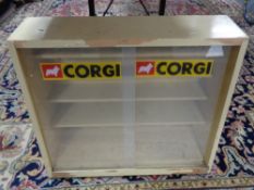 A painted mid century sliding glass door cabinet bearing Corgi advertisement