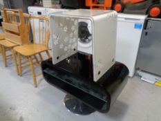 A contemporary black high gloss revolving tv stand on chrome base together with a perspex lamp