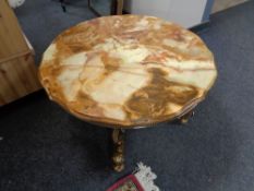 A shaped onyx topped coffee table on ornate brass base
