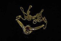 A 10ct yellow gold diamond and ruby pendant suspended on an 18ct gold chain,