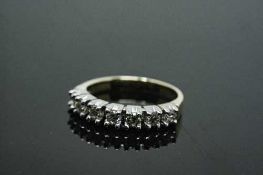 An 18ct white gold seven stone diamond half eternity ring, approximately 0.7ct, size P.