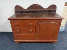 A Victorian pine sideboard fitted with cupboard and three drawers with shelf above
