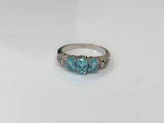 A silver dress ring set with blue stones,